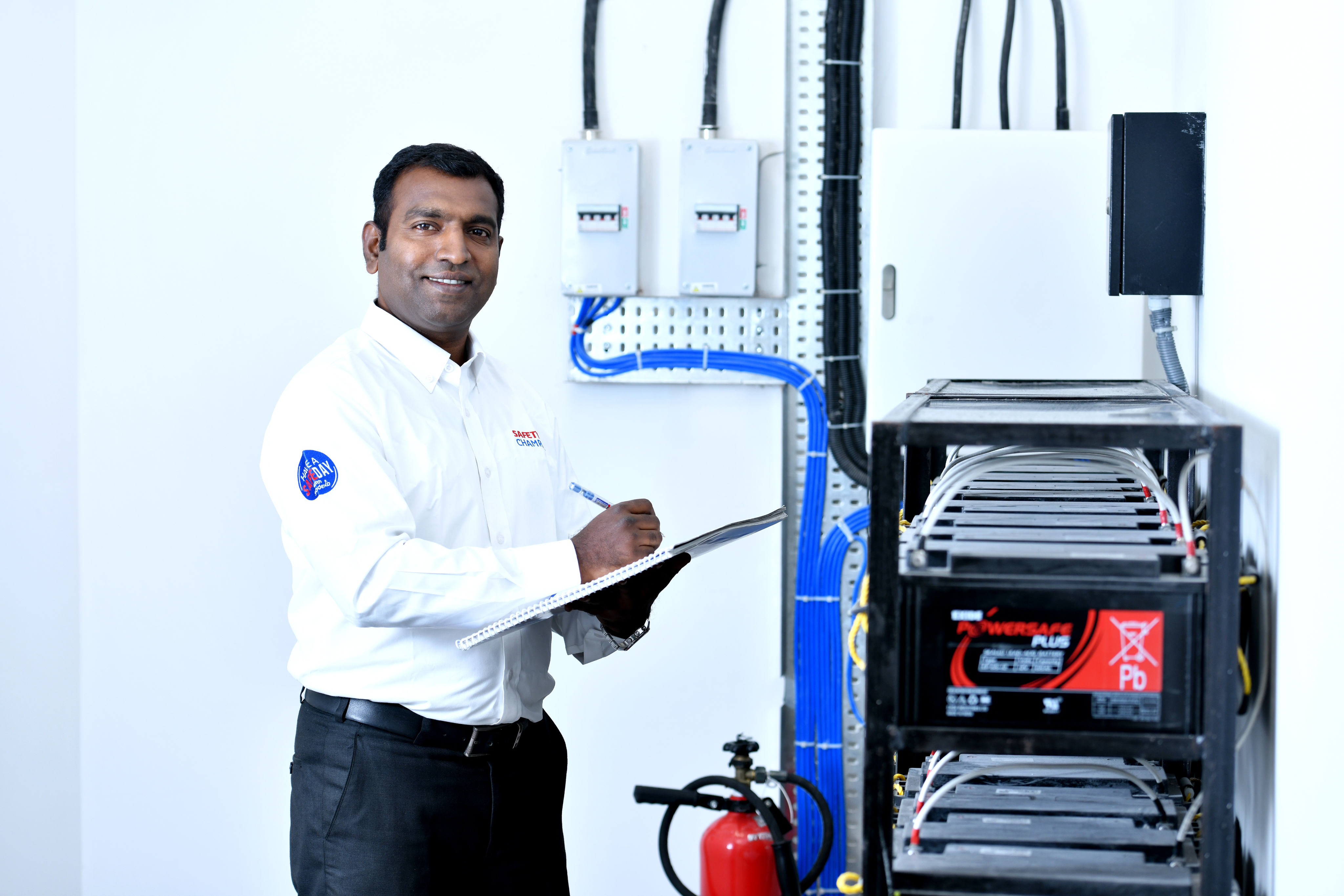 Sodexo employee in a white shirt standing next to a large battery