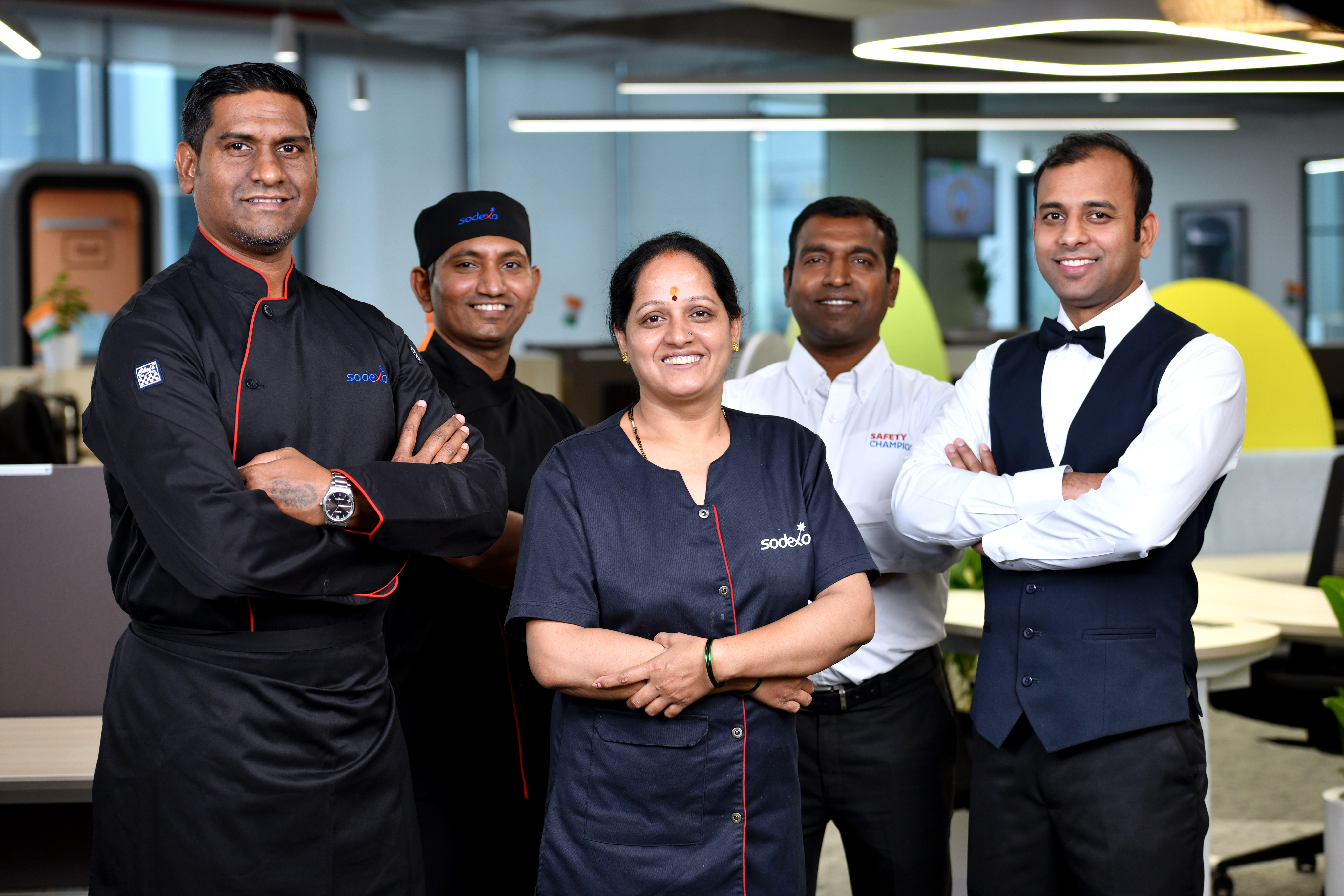 A diverse Sodexo team in uniform and showcasing team spirit.