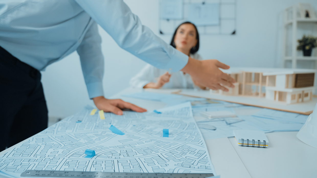 Office colleagues discussing a construction project at a conference table.