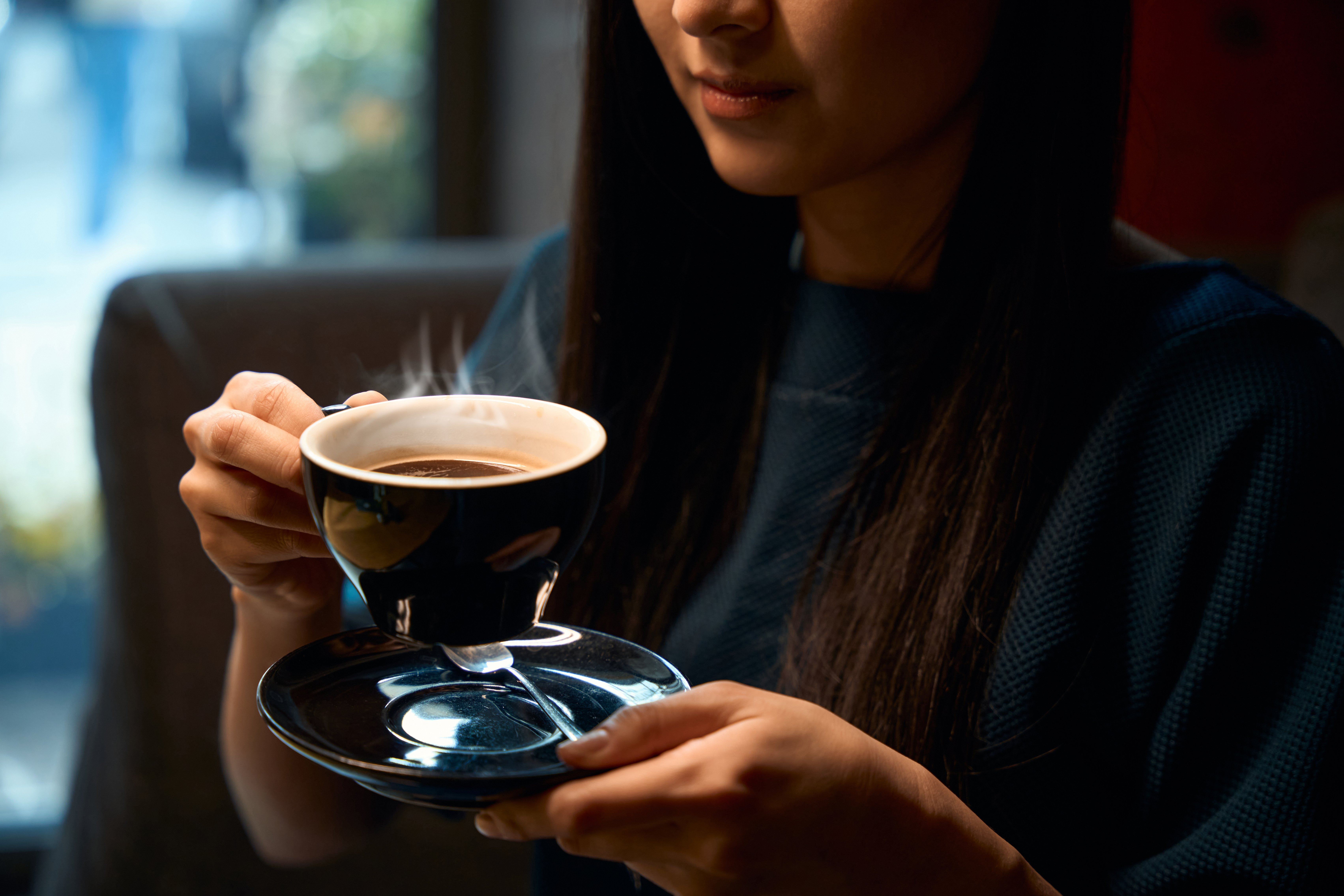 asian-woman-holding-the-cup-of-fresh-and-hot-coffe-2024-07-04-02-39-22-utc