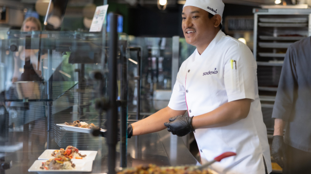 A man serving a meal in a school cafeteria