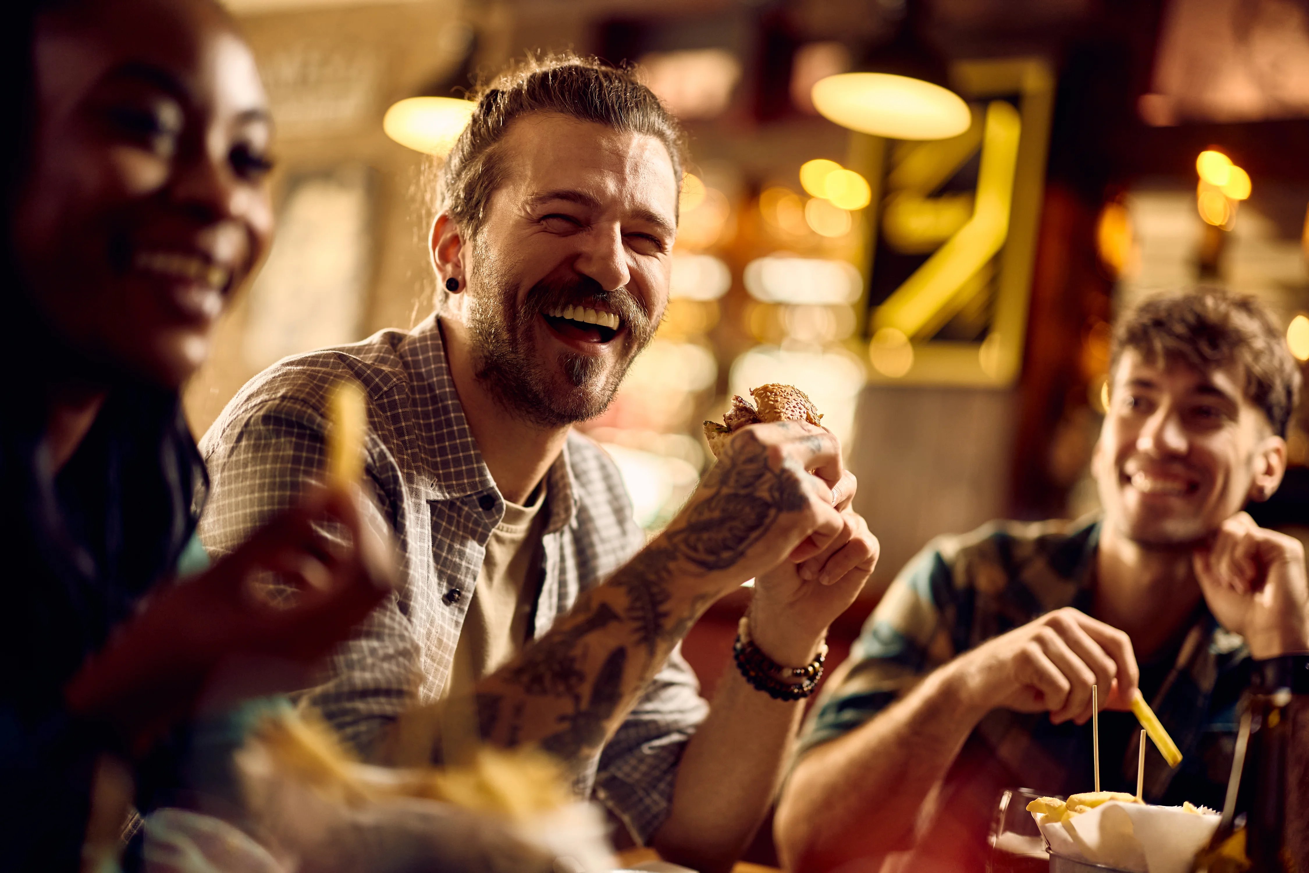 ENERGY&RESOURCES-2025-GLOBAL-Young man laughing and having fun while eating with his friends