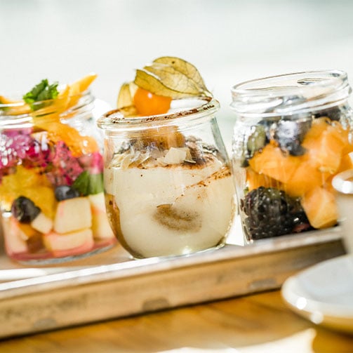 Obstsalat und Tiramisu als Dessert im Glas.