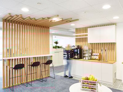 Officebereich mit Kaffeemaschine, Obstkorb, Hochsesseln und Getraenkestation