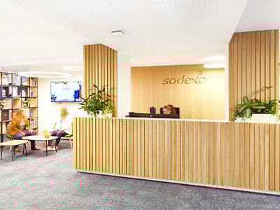 modernes Office in Holzoptik mit Empfang, Sitzecke, Buecherregal und Fernseher