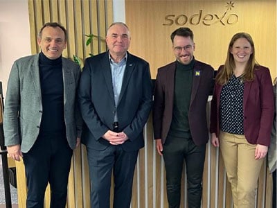 Freundliches Team von Sodexo Mitarbeitern gemeinsam mit Paraschwimmer Andreas Onea im Buero