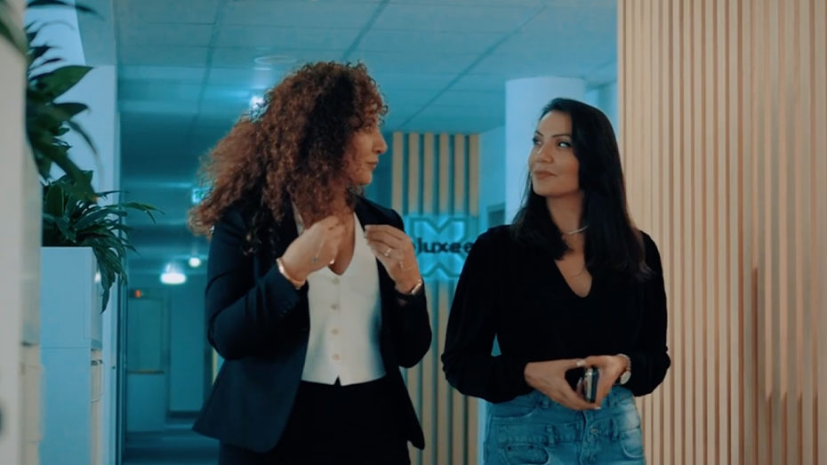 Zwei Frauen unterhalten sich auf dem Gang im Office.