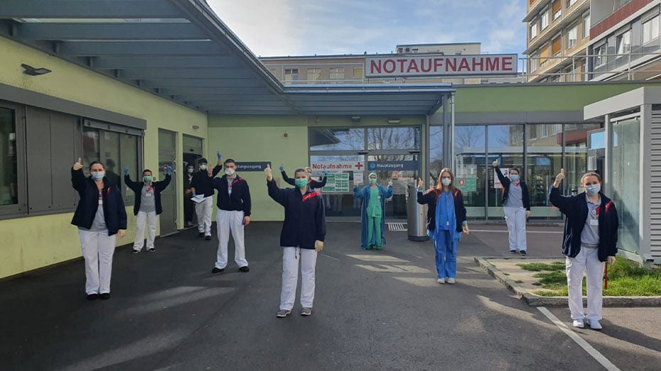 Team mit Sicherheitsabstand vor Notaufnahme