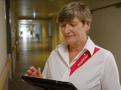 Mitarbeiterin arbeitet konzentriert mit Tablet