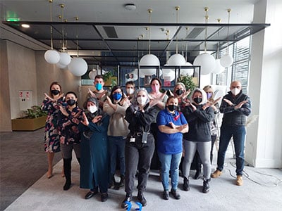 Team zeigt gemeinsam mit Handposition X