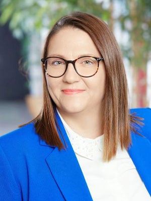 professionelle Frau mit Brille und blauem Blazer