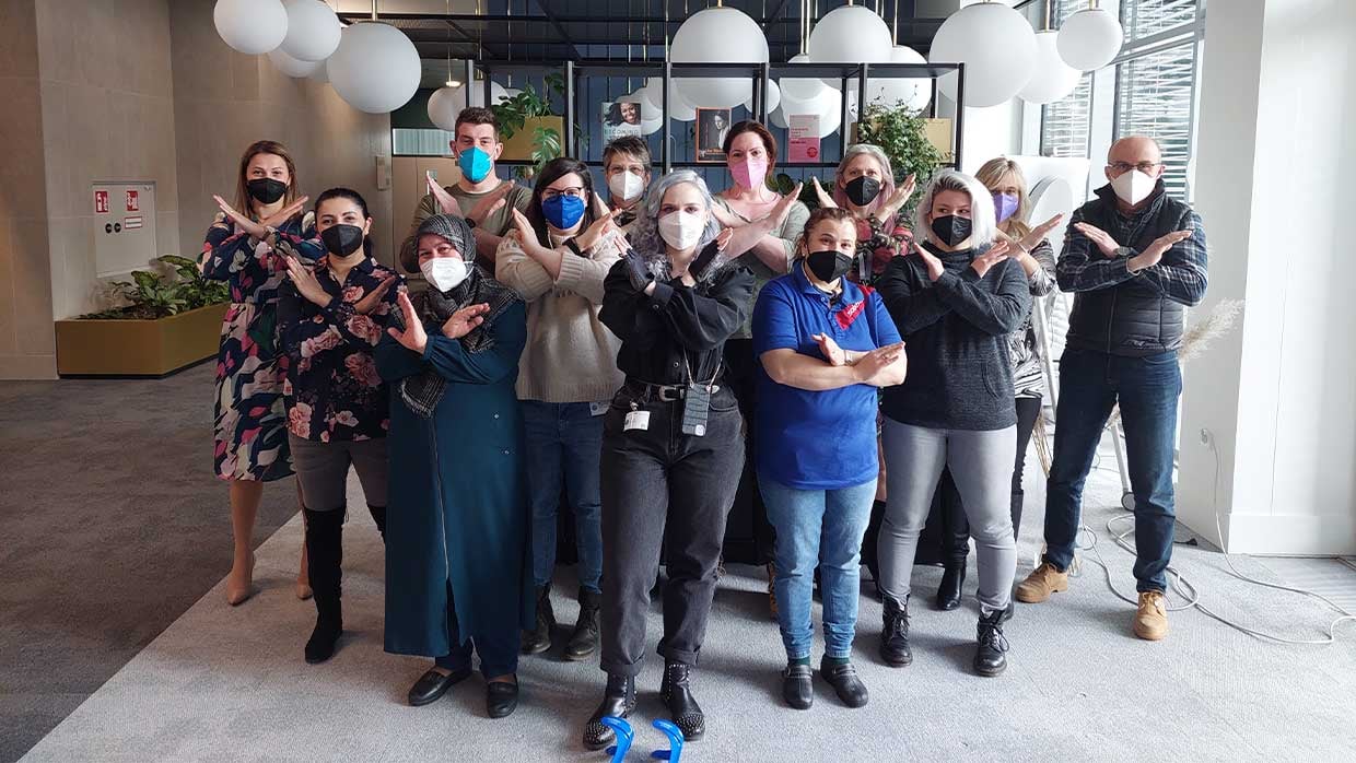 Team zeigt gemeinsam mit Handposition X