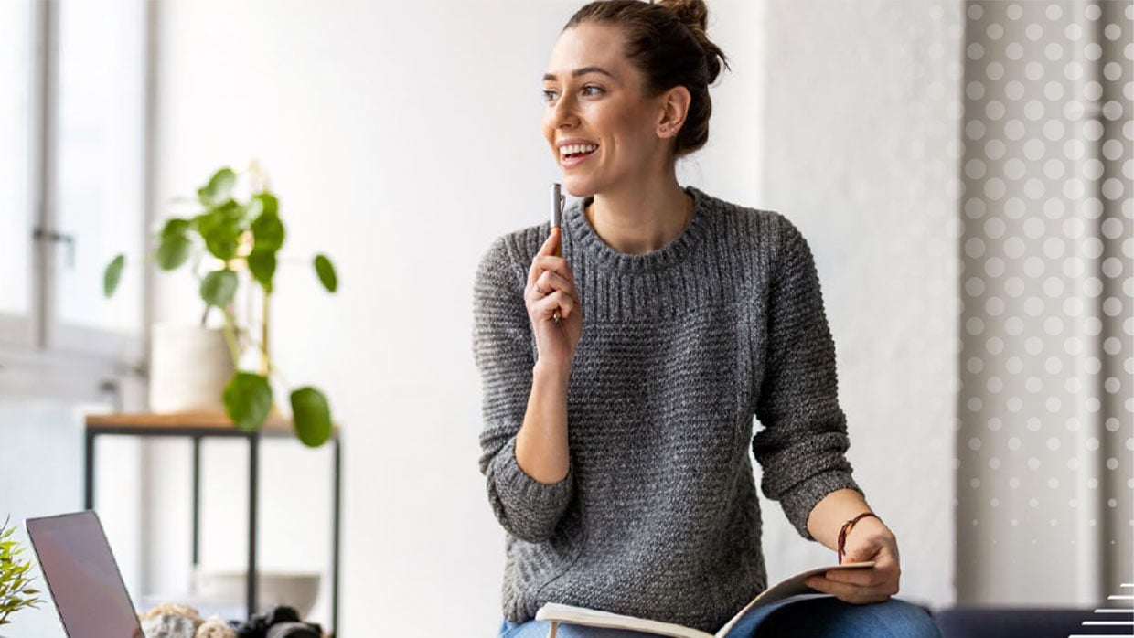 Nachdenkliche junge Frau mit Stift und Buch