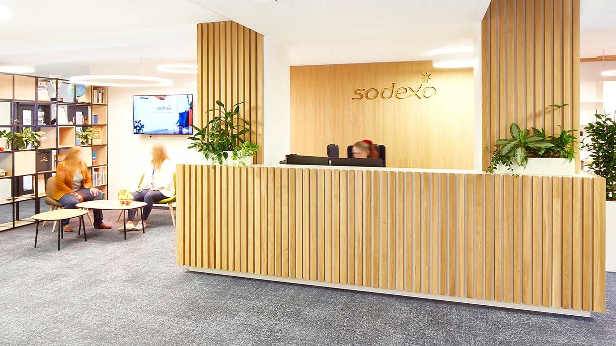modernes Office in Holzoptik mit Empfang, Sitzecke, Buecherregal und Fernseher