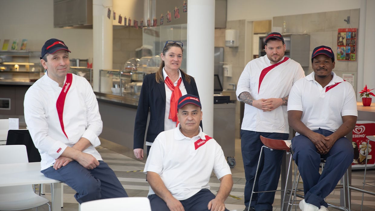 Zufriedenes Team in einheitlichem Arbeitsoutfit