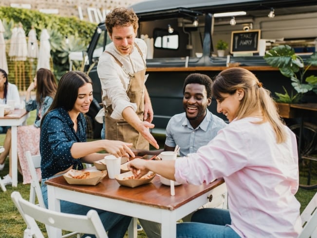 Leute welche in der Unternehmensgastronomie essen, treffen sich am Tisch
