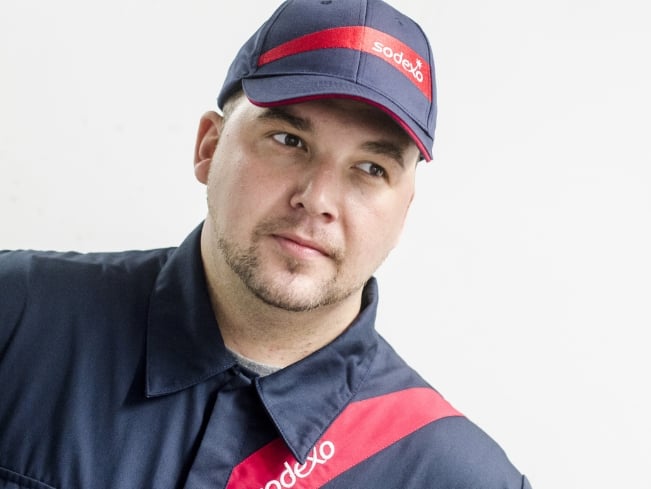 Sodexo Mitarbeitender mit einem Sodexo Capi und einer Sodexo Uniform
