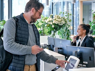 Ein Mann checkt am Sodexo Empfang digital ein