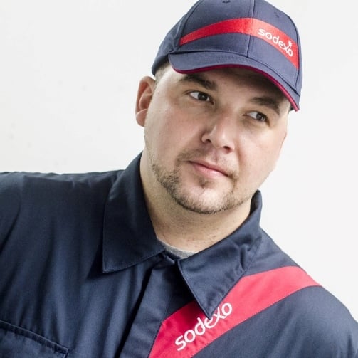 Sodexo Mitarbeitender mit einem Sodexo Capi und einer Sodexo Uniform 