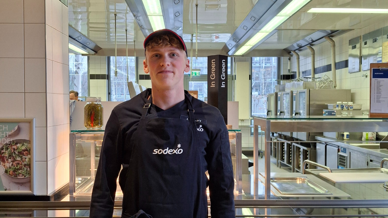 Portrait von Antonio Ferrary vor der Ausgabe eines Betriebsrestaurants. Antonio macht bei Sodexo eine Ausbildung zum Koch.