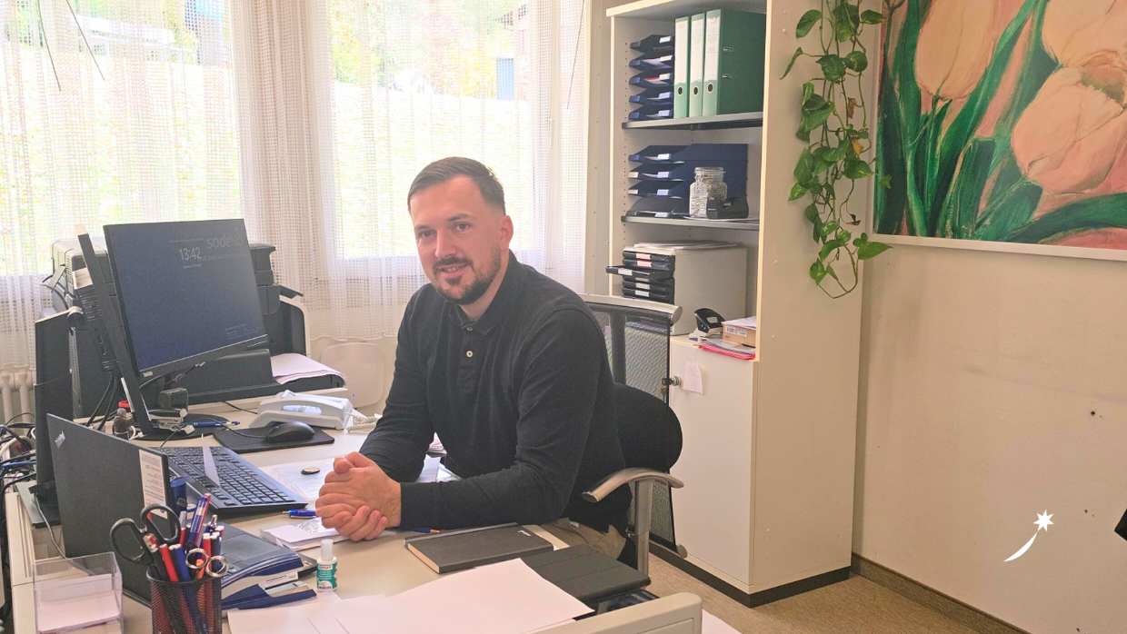 Sodexo Objektleiter Leopold Kolic am Schreibtisch sitzend in seinem Büro.
