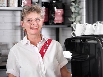 Sodexo-Barista Adina Matejic vor der Kaffeebar in einem Kundenstandort.