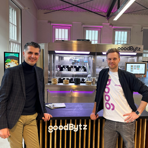 Hadis Berbic, Director Public Catering bei Sodexo Deutschland, und Hendrik Susemihl, GoodBytz CEO, vor einem GoodBytz-Roboter