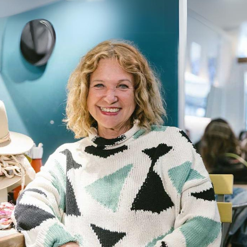 Haya Molcho (Neni) posiert für Sodexo-Kooperation im Hutatelier vor einer Werkbank mit Hüten