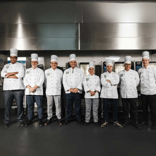 Die sieben Finalisten der Sodexo Sustainable Chef Challenge 2022 posieren vor Rational Küchensystemen.