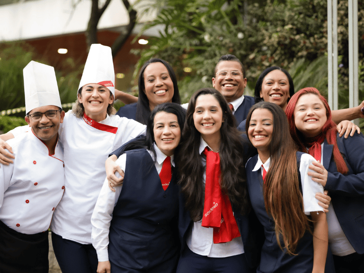 Gruppenbild von lachenden Sodexo-Mitarbeitenden in Arbeitsuniformen.