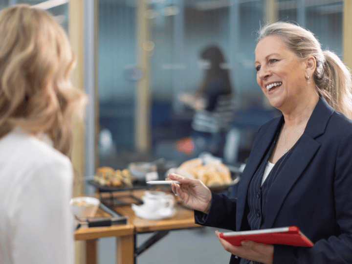 Sodexo-Mitarbeiterin mit Tablet in der Hand im Gespräch mit einer Frau
