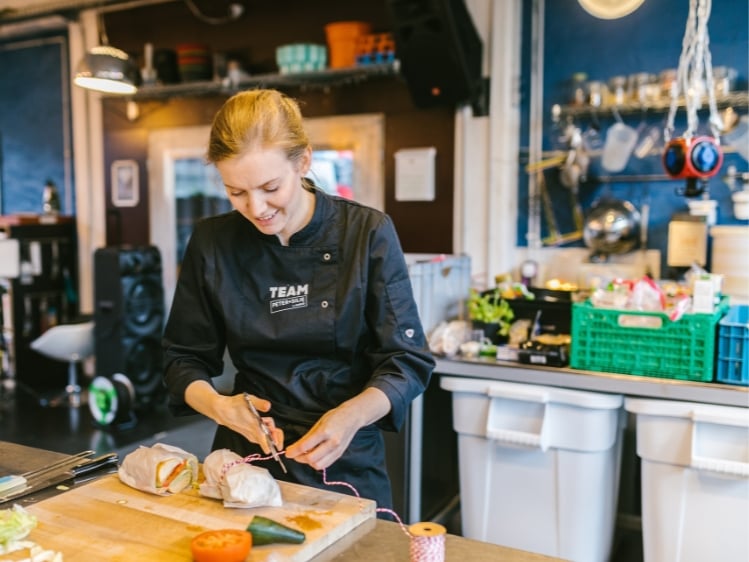 Sodexo Food Expertin Melanie Engesser beim Zubereiten von Sandwich-Päckchen.