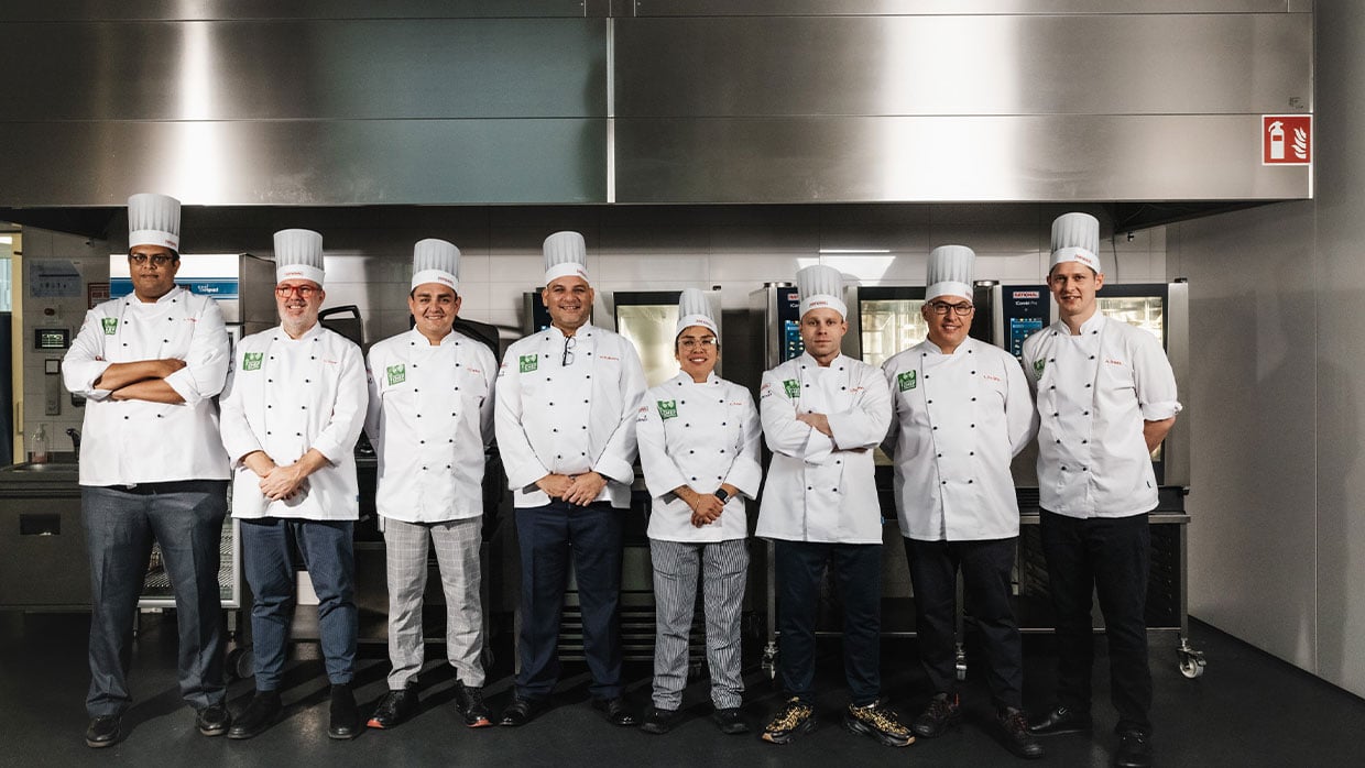 Die sieben Finalisten der Sodexo Sustainable Chef Challenge 2022 posieren vor Rational Küchensystemen.