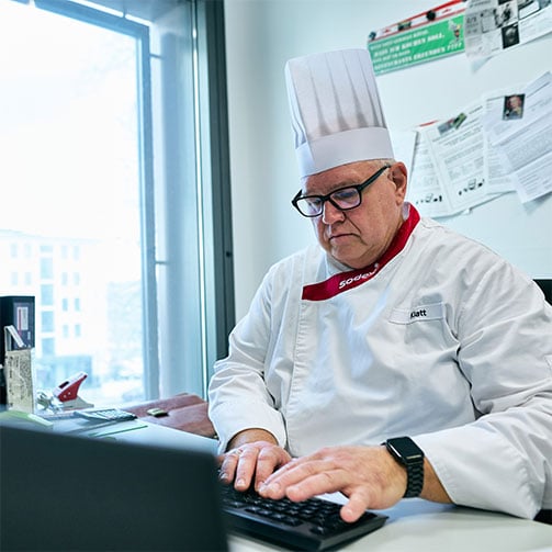 Sodexo-Betriebsleiter Thomas Klatt im Büro beim Tippen am Computer