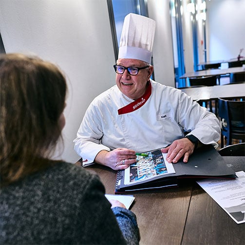 Sodexo-Betriebsleiter Thomas Klatt im Gespräch mit einer Kundin rund um das Food-Angebot