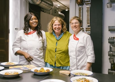 Starköchin Haya Molcho (Neni) posiert mit den zwei Sodexo-Köchinnen Catherine Richert und Anja Rotte in ihrer Küche in Wien hinter den von ihnen zubereiteten Gerichten.