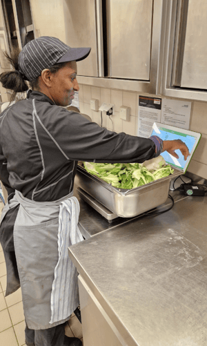 Eine Sodexo-Mitarbeiterin wiegt Lebensmittelabfälle mit dem WasteWatch-Programm.