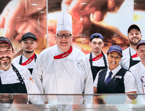 Sodexo-Betriebsleiter Thomas Klatt im Gruppenbild mit einem Teil seines Mitarbeiter-Teams an der Essensausgabe