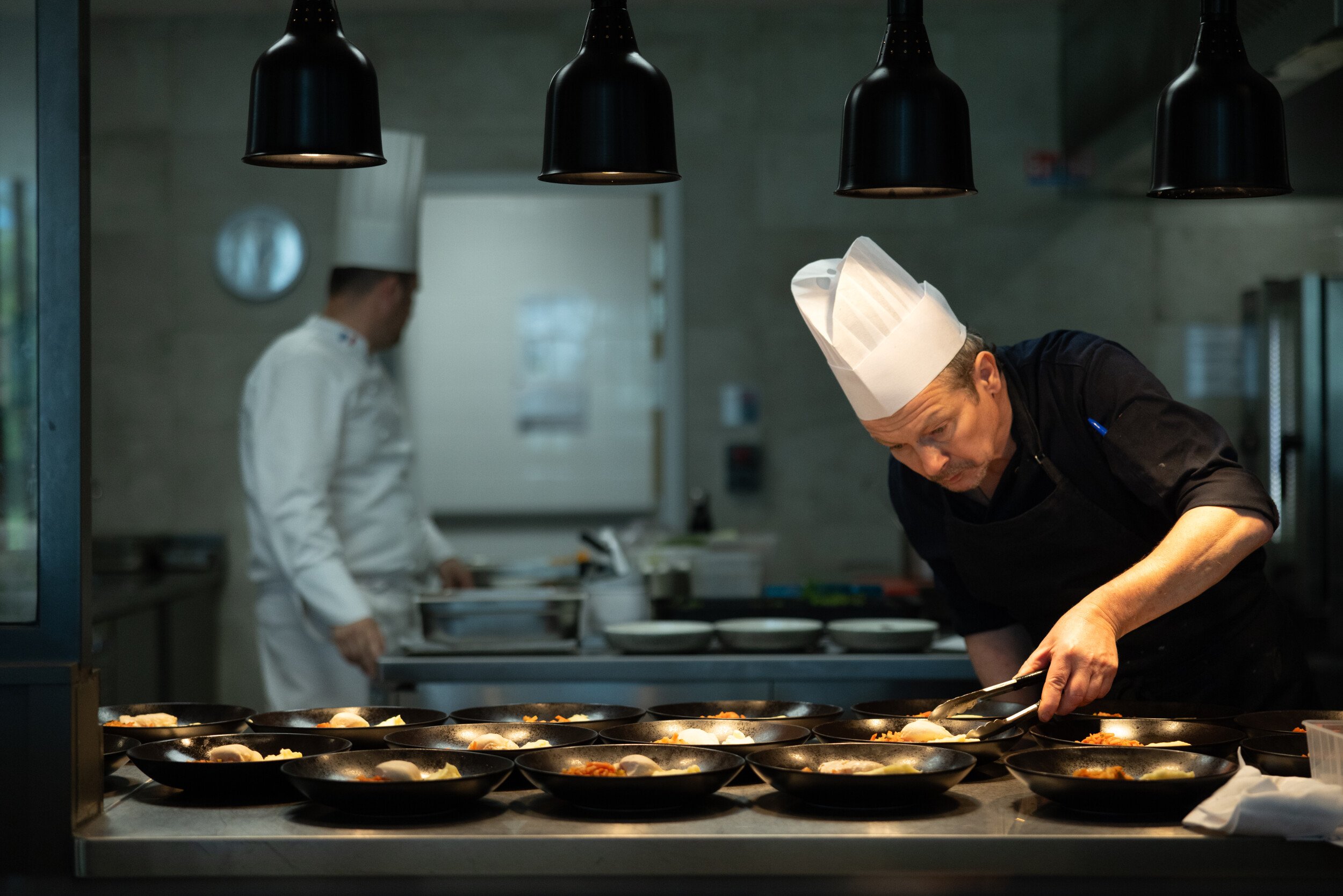 Cocinero terminando platos en una cocina