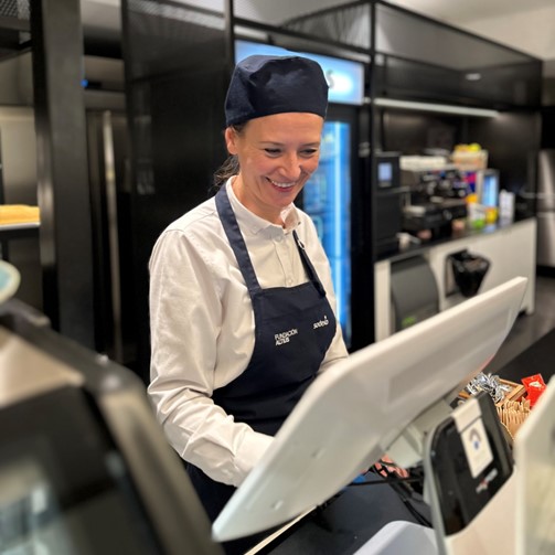 Mujer con un delantal de Sodexo en una cafetería