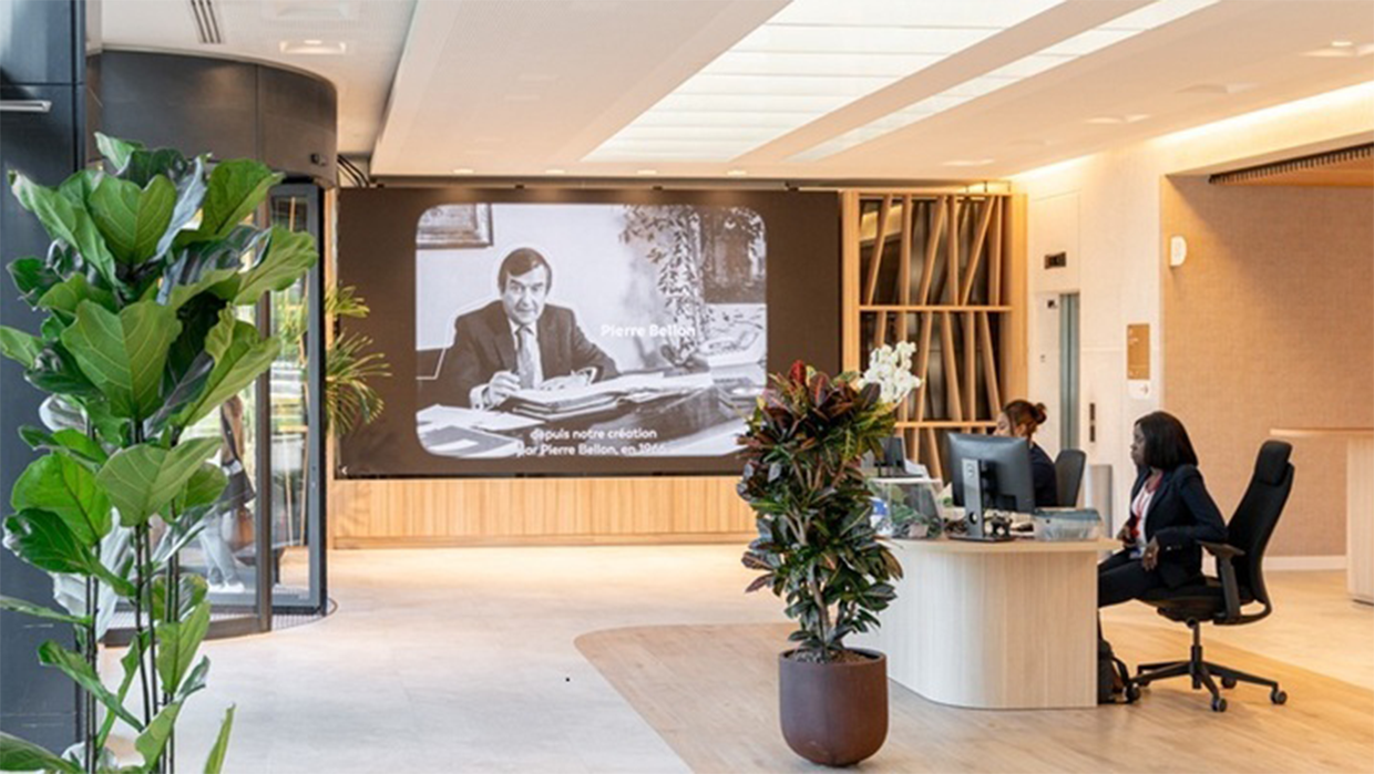 Isossa toimistotilassa istuu henkilö työpöydän ääressä