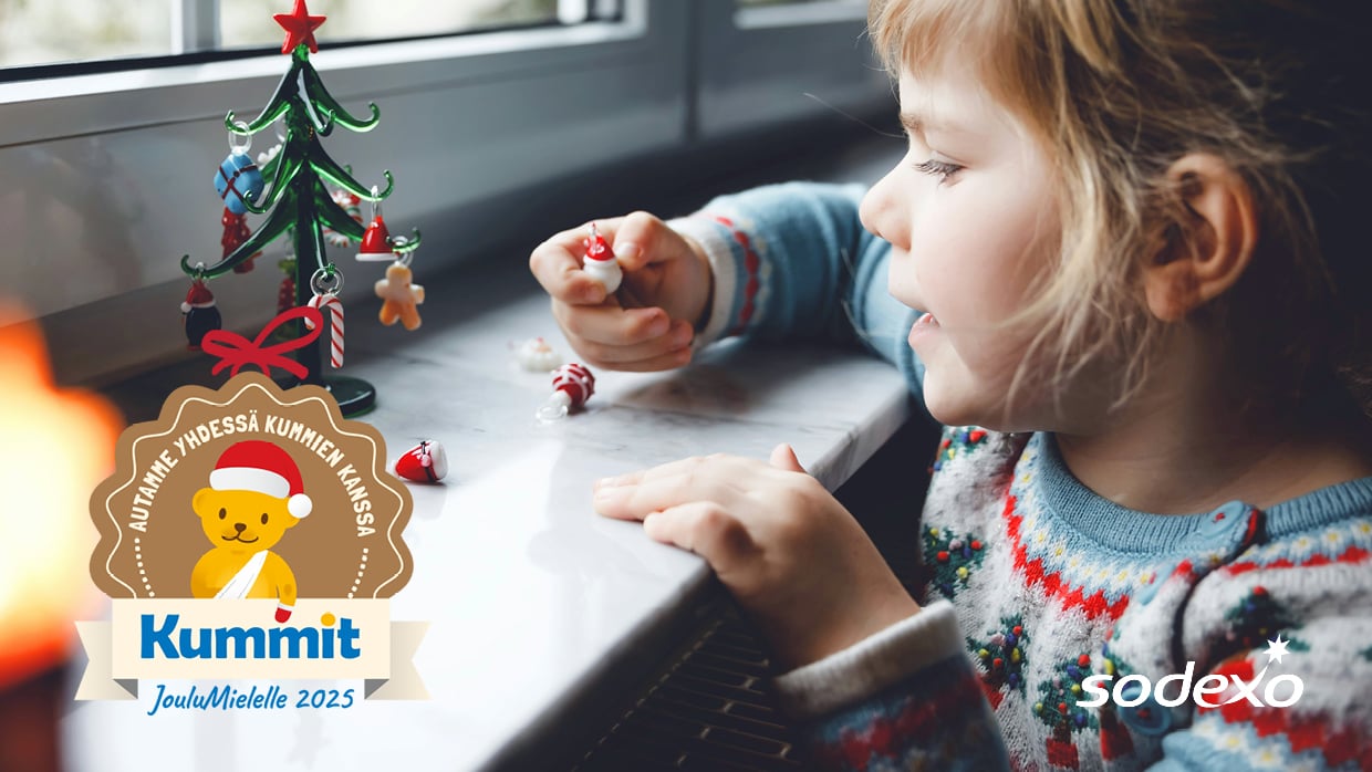 lapsi tutkii joulukoristeita ikkunan ääressä