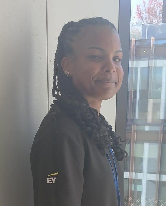 Portrait of a Sodexo colleague wearing a blue Sodexo polo shirt against a plain light-coloured background.