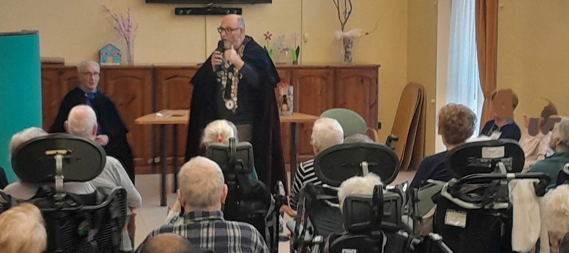 Gran Maestro della Confraternita del Folpo parla a persone anziane disabili