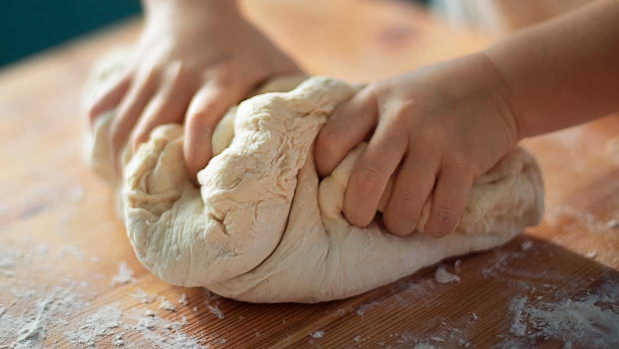 Bambino impasta la farina per l'evento "Mani in Pasta" organizzato da Sodexo nei comuni di Rubicone