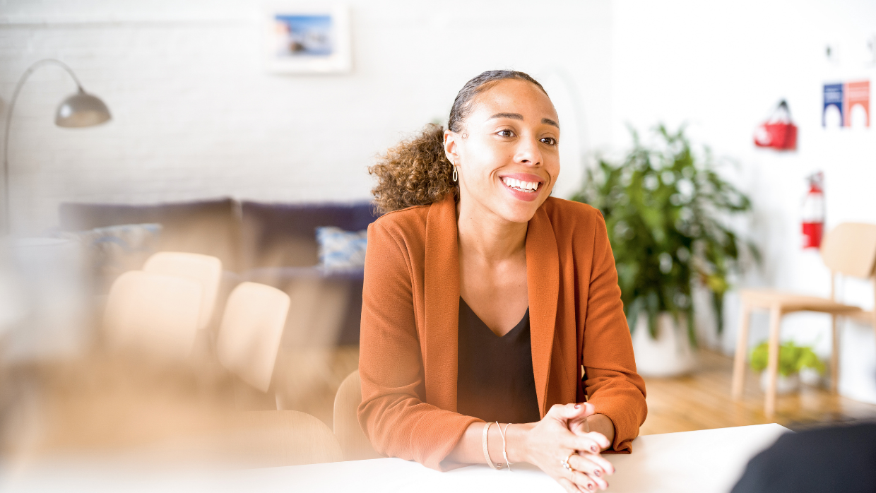 Kvinna som sitter och pratar med en kollega på ett kontor