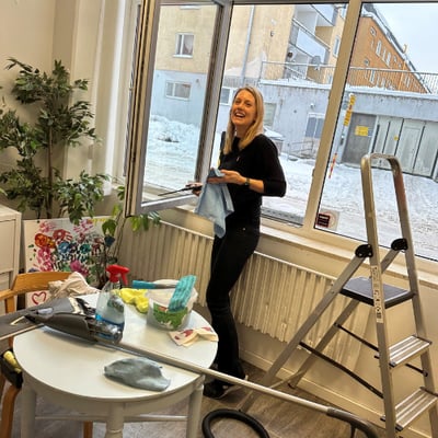 Kristina tvättar fönster under volontärdagen på Mötesplats Vårberg