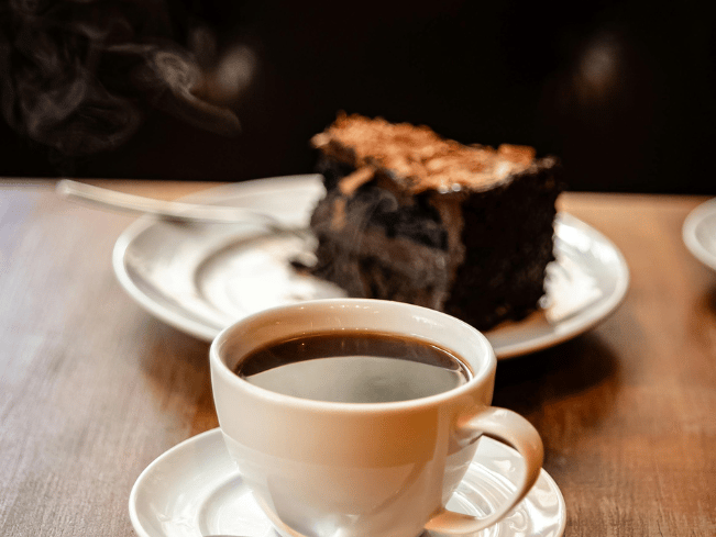 Någon som beställt kaffe och en kaka på ett café