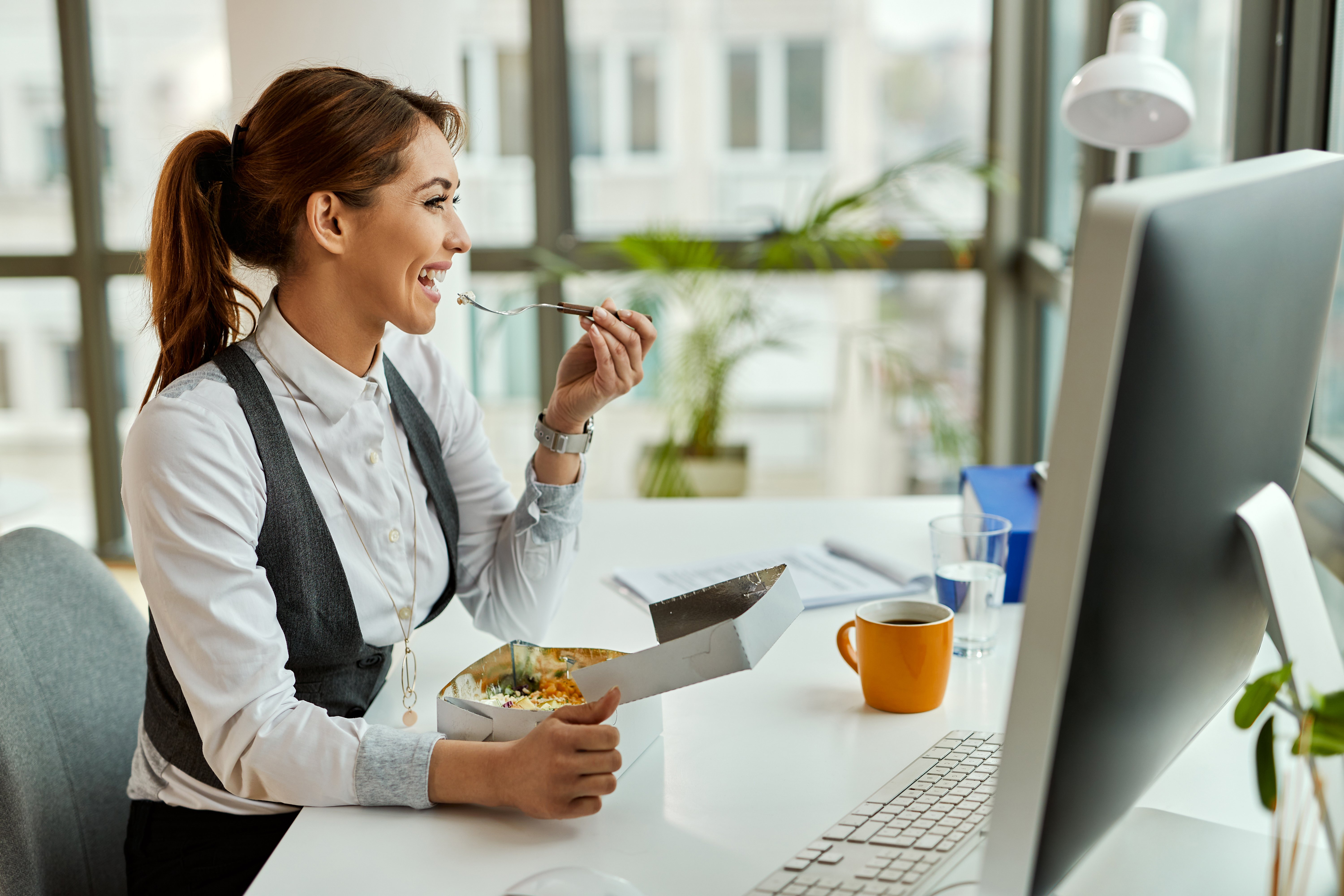 young-happy-businesswoman-eating-break-office