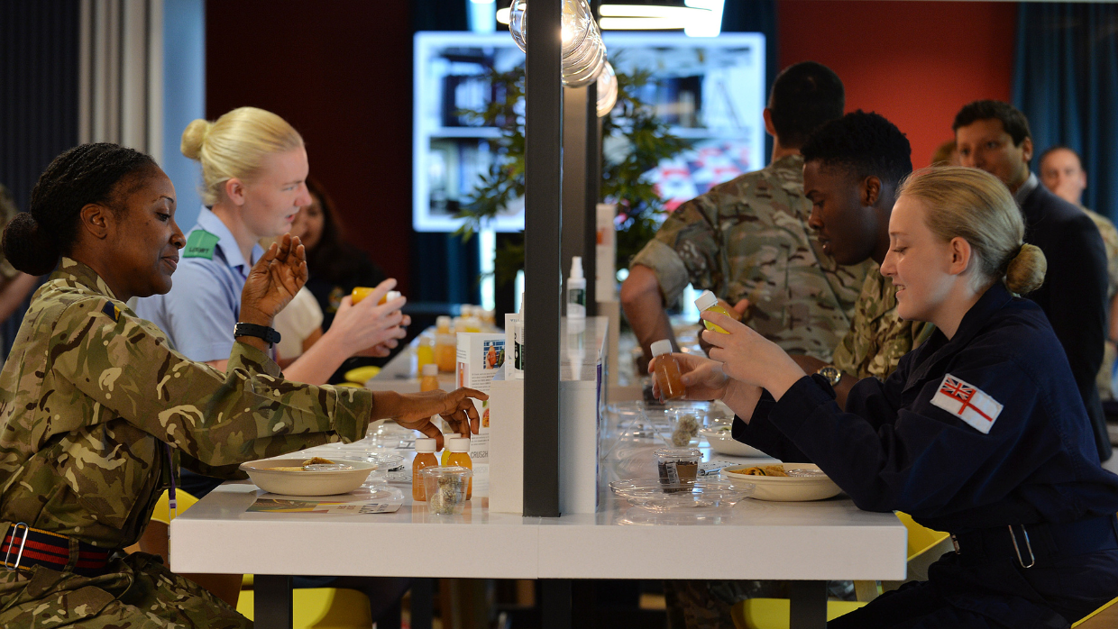 A group of people sitting around a table, eating and socializing in a warm and inviting atmosphere.